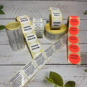 Custom printed satin ribbons and glossy logo stickers in assorted vibrant colours for professional gift packaging.